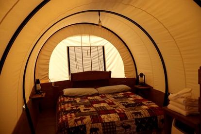 Rustic Conestoga Wagon Stay with Lodge Amenities near Boulder Creek, Montana - Hall, Montana - glamping.directory