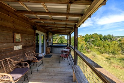 Beautiful Cabin with Deck and Hot Tub Overlooking Spring Creek in Texas - glamping.directory