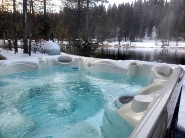Charming Riverfront Cabin with Hot Tub and Dock Access Near Scenic Trails in Island Park, Idaho - Island Park, Idaho - glamping.directory