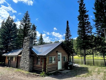 Charming Riverfront Cabin with Hot Tub and Dock Access Near Scenic Trails in Island Park, Idaho - Island Park, Idaho - glamping.directory